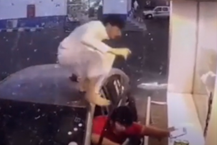 Saudi youth climbs on top of car to pay the bills first at drive-through store